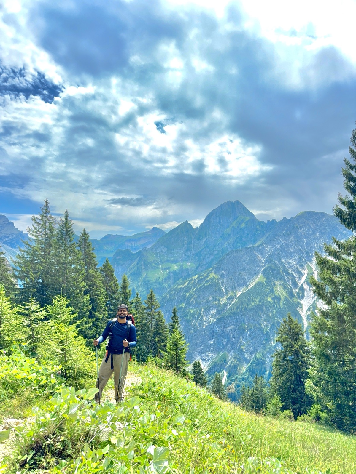 Hiking up a grassy ridge trail with jagged Allgäu peaks behind