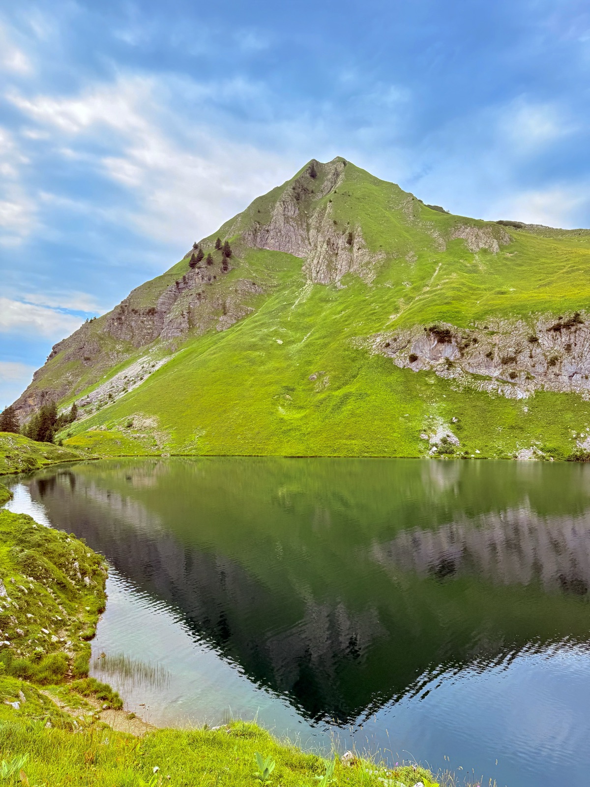 The peak above Seealpsee mirrored perfectly in the still water